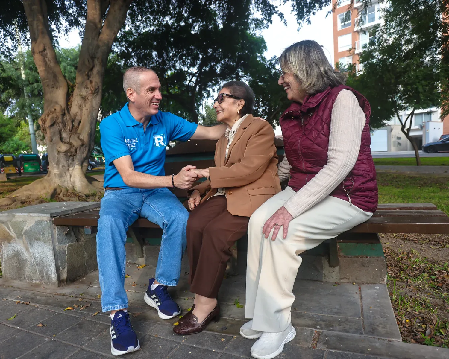 Javier Diez conversa con dos vecinas sentadas en una banca del parque